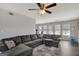Comfortable living room with a plush gray sectional, ceiling fan, and natural light from multiple windows at 912 Shadow Ridge Cir, Stockbridge, GA 30281