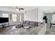 Open living room with gray sectional, leading to the kitchen with black appliances, and a bright dining area at 912 Shadow Ridge Cir, Stockbridge, GA 30281