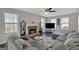 Living room with brick fireplace, large windows and a comfortable sectional sofa with accent pillows at 912 Shadow Ridge Cir, Stockbridge, GA 30281