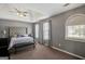 Light-filled main bedroom with tray ceilings, a tufted headboard, and large windows at 912 Shadow Ridge Cir, Stockbridge, GA 30281