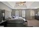 Spacious main bedroom featuring a tray ceiling, large windows, and a cozy, tufted headboard for a luxurious feel at 912 Shadow Ridge Cir, Stockbridge, GA 30281