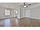 Open living area features wood flooring, modern light fixture, and access to kitchen at 202 Saltlick Trce, Peachtree City, GA 30269