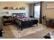 Well-lit bedroom featuring a black bed frame, open window, and patterned rug at 275 Nutt Dr, Locust Grove, GA 30248