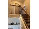 Staircase featuring wood railing, neutral walls, and decorative art in the background at 275 Nutt Dr, Locust Grove, GA 30248