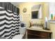 Cozy bathroom with black and white patterned shower curtain, bright yellow walls, and granite vanity top at 1055 Adrian Sw Cir, Conyers, GA 30094