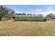 Exterior view of the home's backyard, showcasing green siding and a spacious lawn area at 1055 Adrian Sw Cir, Conyers, GA 30094