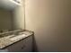 Well-lit half bathroom featuring granite countertops and a large mirror at 2795 Oxford Dr, Decatur, GA 30034