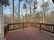 An elevated wooden deck with a railing offering a view of the surrounding trees at 6220 Grovener Ave, Douglasville, GA 30134