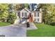 Charming home featuring a two-car garage, inviting front porch, manicured lawn, and surrounded by mature trees at 6220 Grovener Ave, Douglasville, GA 30134