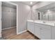 Bathroom boasts wood floors, double sink vanity, glass shower, and a walk-in closet at 301 Amsterdam Way, Hampton, GA 30228