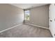 Comfortable bedroom with neutral carpet, a window offering natural light, and a sleek door at 301 Amsterdam Way, Hampton, GA 30228