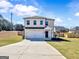 Two-story home featuring a brick exterior, attached two-car garage, and well-manicured front lawn at 301 Amsterdam Way, Hampton, GA 30228