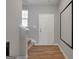 Bright foyer with hardwood floors, leading to a staircase and featuring a white front door at 301 Amsterdam Way, Hampton, GA 30228