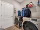 Functional laundry room featuring modern washer and dryer units, storage shelves, and convenient access at 301 Amsterdam Way, Hampton, GA 30228