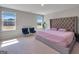 Serene bedroom featuring plush carpeting, two large windows, and a tufted headboard at 301 Amsterdam Way, Hampton, GA 30228