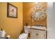 Charming powder room featuring stylish mirror, granite countertop, and updated fixtures at 9800 Ivey Ridge Cir, Jonesboro, GA 30238