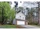 Two-story home with gray siding, brick accents, and a two-car garage surrounded by lush green trees and landscaping at 3821 Rex Mill Sq, Rex, GA 30273