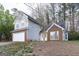 Two-story home with gray siding and brick accents with an attached two-car garage surrounded by mature trees at 3821 Rex Mill Sq, Rex, GA 30273