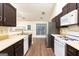 Galley-style kitchen with stainless steel appliances, white countertops, and dark wood cabinets with an eat in area at 3821 Rex Mill Sq, Rex, GA 30273