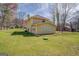 Large backyard featuring lush green grass, mature trees, and partial views of the home's exterior at 440 Cottonpatch Rd, Lawrenceville, GA 30046