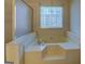 This bathroom features a soaking tub with tile surround and a window for natural light at 440 Cottonpatch Rd, Lawrenceville, GA 30046
