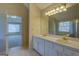 Bright bathroom featuring a double vanity, decorative lighting, and doorway to another bedroom or living space at 440 Cottonpatch Rd, Lawrenceville, GA 30046
