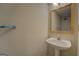 Well-lit bathroom featuring a pedestal sink, gold-trimmed mirror, and neutral wall; inviting and functional at 440 Cottonpatch Rd, Lawrenceville, GA 30046