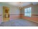 Bright dining room featuring a chandelier, large window, and access to the adjacent kitchen at 440 Cottonpatch Rd, Lawrenceville, GA 30046