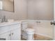 Neutral powder room with classic fixtures and white vanity at 650 Moseley Rd, Stockbridge, GA 30281
