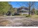 Inviting two-story house with a classic porch, a separate small barn-like building, and a large driveway in a rural setting at 650 Moseley Rd, Stockbridge, GA 30281