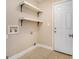 Laundry room features a white door, floating shelves, and tiled floors at 650 Moseley Rd, Stockbridge, GA 30281