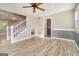 Open-concept living area with wood-look floors, staircase, doorway to kitchen and a ceiling fan at 650 Moseley Rd, Stockbridge, GA 30281