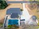 Aerial view of a property with a covered pool, long driveway, gazebo, and tree-lined surroundings at 3798 Cumberland Way, Lithonia, GA 30038