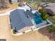 An aerial shot of a brick home highlighting the backyard pool, outdoor living space, and mature trees at 3798 Cumberland Way, Lithonia, GA 30038