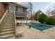 Inviting backyard featuring a pool with a cover, complemented by an elevated deck and serene surroundings at 3798 Cumberland Way, Lithonia, GA 30038
