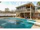 Expansive backyard with a covered pool, a spacious patio beneath an elevated deck, perfect for outdoor activities at 3798 Cumberland Way, Lithonia, GA 30038