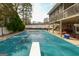 A large backyard showcasing a covered pool and an elevated deck, offering a serene and private outdoor space at 3798 Cumberland Way, Lithonia, GA 30038