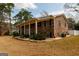 Brick home with symmetrical windows, covered porch, and professional landscaping offers charm and curb appeal at 3798 Cumberland Way, Lithonia, GA 30038