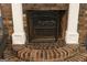 Close-up of a brick fireplace with a decorative screen and classic white mantel at 3798 Cumberland Way, Lithonia, GA 30038