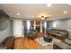 Cozy living room with a brick fireplace, wood floors, comfortable seating, and ample natural light at 3798 Cumberland Way, Lithonia, GA 30038