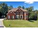 Stunning two-story brick home boasts lush landscaping and a well-manicured lawn under a bright, partly cloudy sky at 3015 Gold Creek Dr, Villa Rica, GA 30180