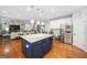 Modern kitchen showcasing an island with dark cabinets, stainless steel appliances, and an open layout connecting to the living area at 3015 Gold Creek Dr, Villa Rica, GA 30180