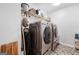 Laundry room featuring stainless steel appliances, storage racks, and gray tile floors at 3015 Gold Creek Dr, Villa Rica, GA 30180