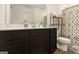 This bathroom features a dark vanity, large mirror, toilet, and patterned shower curtain at 11882 Fuller St, Hampton, GA 30228