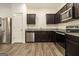 Modern kitchen featuring dark cabinets, stainless steel appliances, and granite countertops at 11882 Fuller St, Hampton, GA 30228