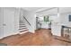 Open concept living space with hardwood floors, white walls, stairs and a kitchen with stainless steel appliances at 1893 Burning Tree, Decatur, GA 30032