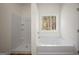 Bright bathroom featuring a separate shower and soaking tub, with natural light from a window at 105 Creekside Knl, Grantville, GA 30220