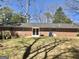 Exterior view of a brick home featuring a backyard with grass and patio with blue skies at 4572 Sahara Sw Dr, Atlanta, GA 30331