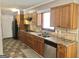 Well-lit kitchen featuring a stainless steel dishwasher, black cooktop and wood cabinetry at 4572 Sahara Sw Dr, Atlanta, GA 30331