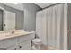 Well-lit bathroom featuring a single vanity, toilet, and shower with white curtain at 306 Turtle Pointe Dr, Carrollton, GA 30116